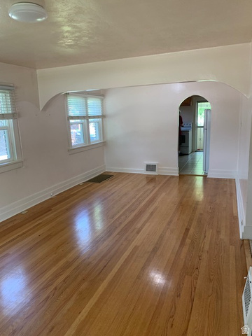 2205 East 3300 South Millcreek, UT 84109 - Photo 8 of 23 Spacious room featuring wood-finish flooring, white baseboards, and multiple windows with blinds