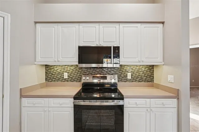 a view of empty room with cabinet and windows