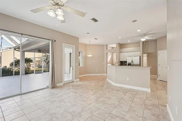 an empty room with an entryway and chandelier fan