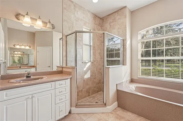 a bathroom with a granite countertop sink a toilet a mirror and shower