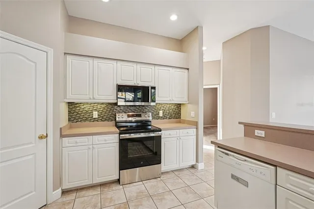 a view of kitchen with kitchen island and stainless steel appliances