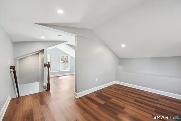 a view of empty room with wooden floor