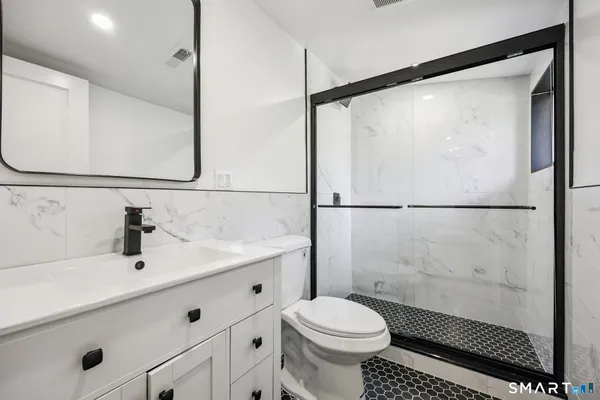 a bathroom with a sink a toilet and shower