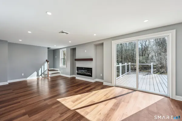 a view of empty room with wooden floor and fireplace