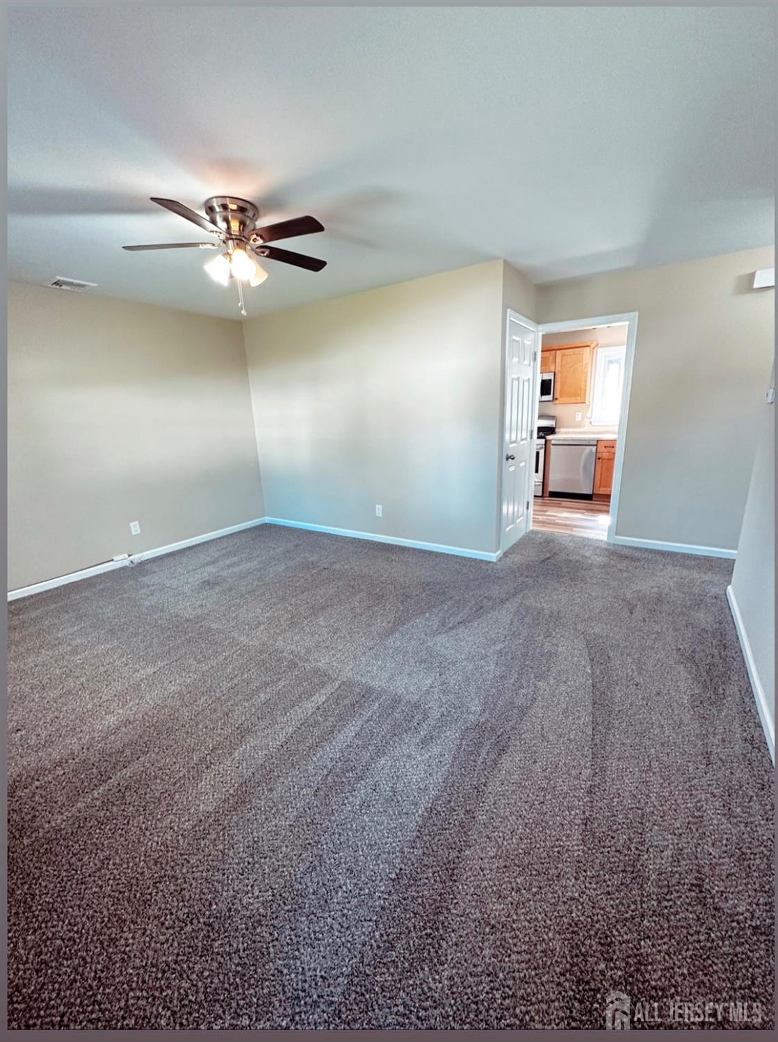 32 Apple Street Edison, NJ 08817 - Photo 6 of 11 a view of an empty room with window and chandelier fan