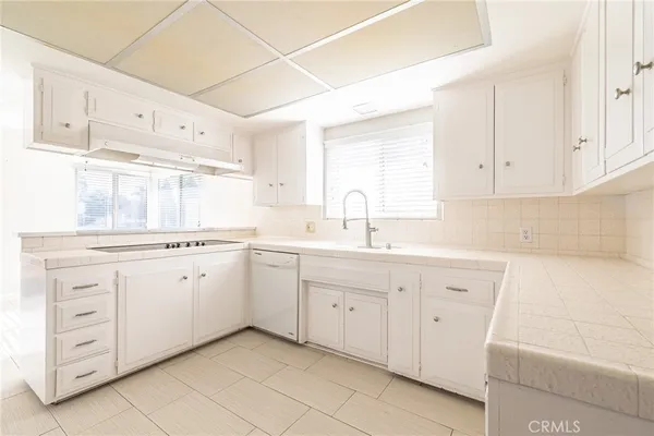 a kitchen with cabinets appliances a sink and a window