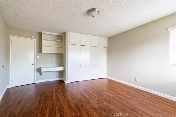 a view of empty room with wooden floor and window