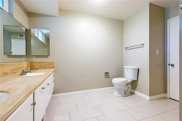 a spacious bathroom with a toilet sink and mirror