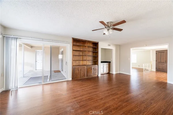 a view of a big room with wooden floor and a ceiling fan