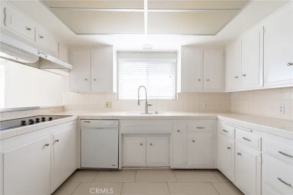 a kitchen with cabinets appliances a sink and a window