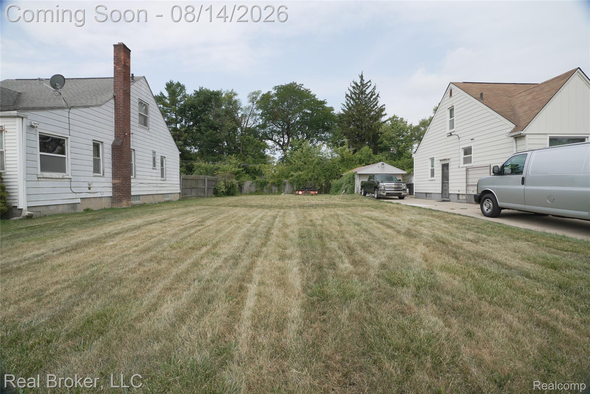 9557 Meyers Road Detroit, MI 48227 - Photo 3 of 23 Expansive grass area with a paved driveway and detached garage