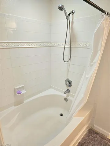 a bathroom with a bath tub with a shower