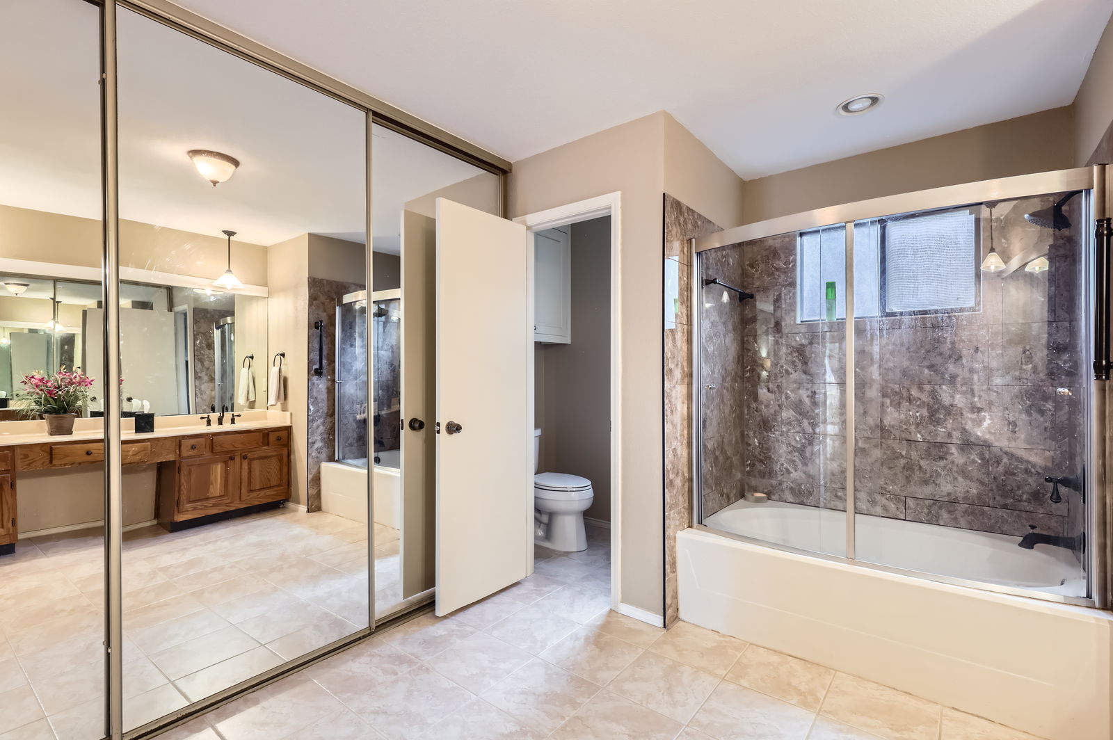 4513 Sidereal Drive Austin, TX 78727 - Photo 21 of 38 Primary bathroom with tile flooring, closet with mirrored sliding doors and separate toilet area.
