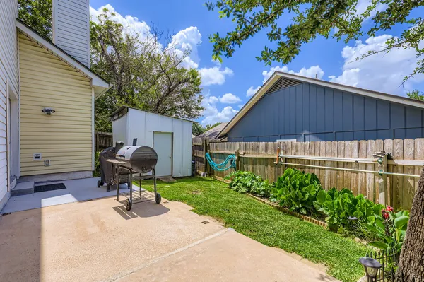 a view of a chair and table in backyard of the house