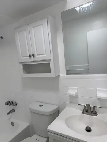 a bathroom with a sink a toilet and mirror