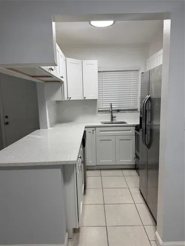 a kitchen with a sink a refrigerator and cabinets