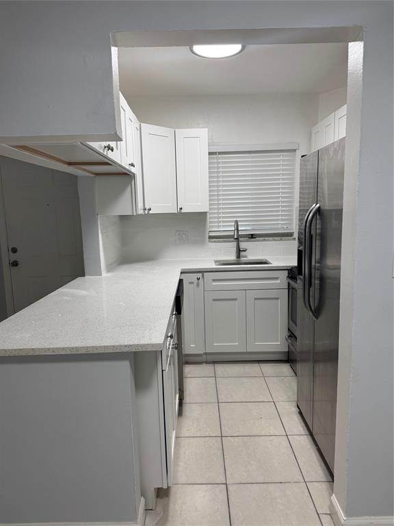 3050 Northeast 5th Terrace, Unit 6 Wilton Manors, FL 33334 - Photo 7 of 22 a kitchen with a sink a refrigerator and cabinets