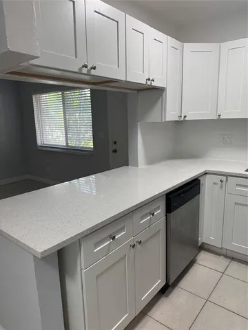 a kitchen with granite countertop white cabinets and white appliances