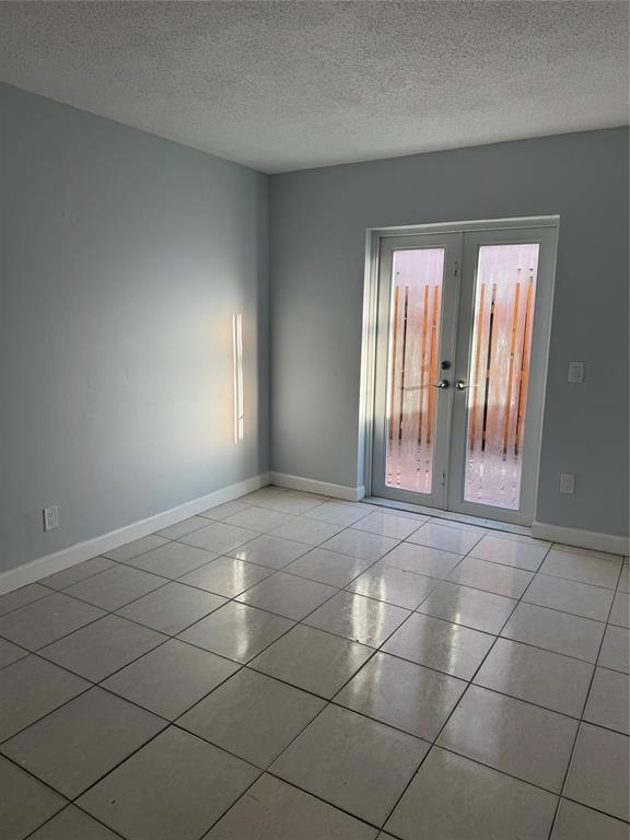 3050 Northeast 5th Terrace, Unit 6 Wilton Manors, FL 33334 - Photo 10 of 22 an empty room with windows