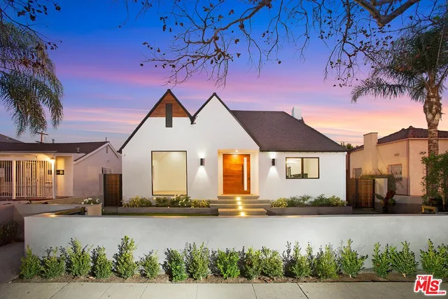 a front view of a house with a yard and lake view