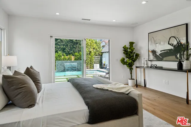 a bedroom with a large bed and a potted plant