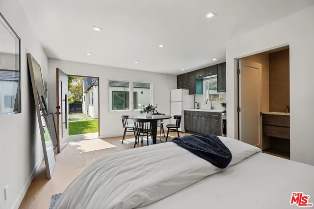 a bedroom with a bed and a view of kitchen
