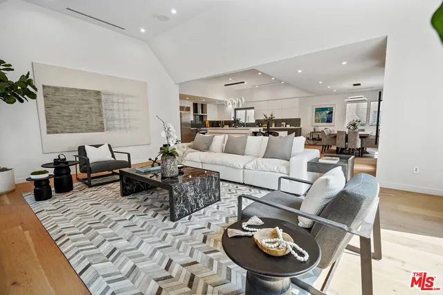a living room with furniture a rug and kitchen view