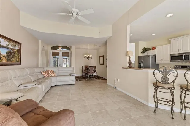 a living room with furniture a kitchen view and a fireplace