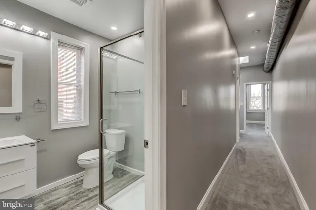 a bathroom with a sink toilet and window