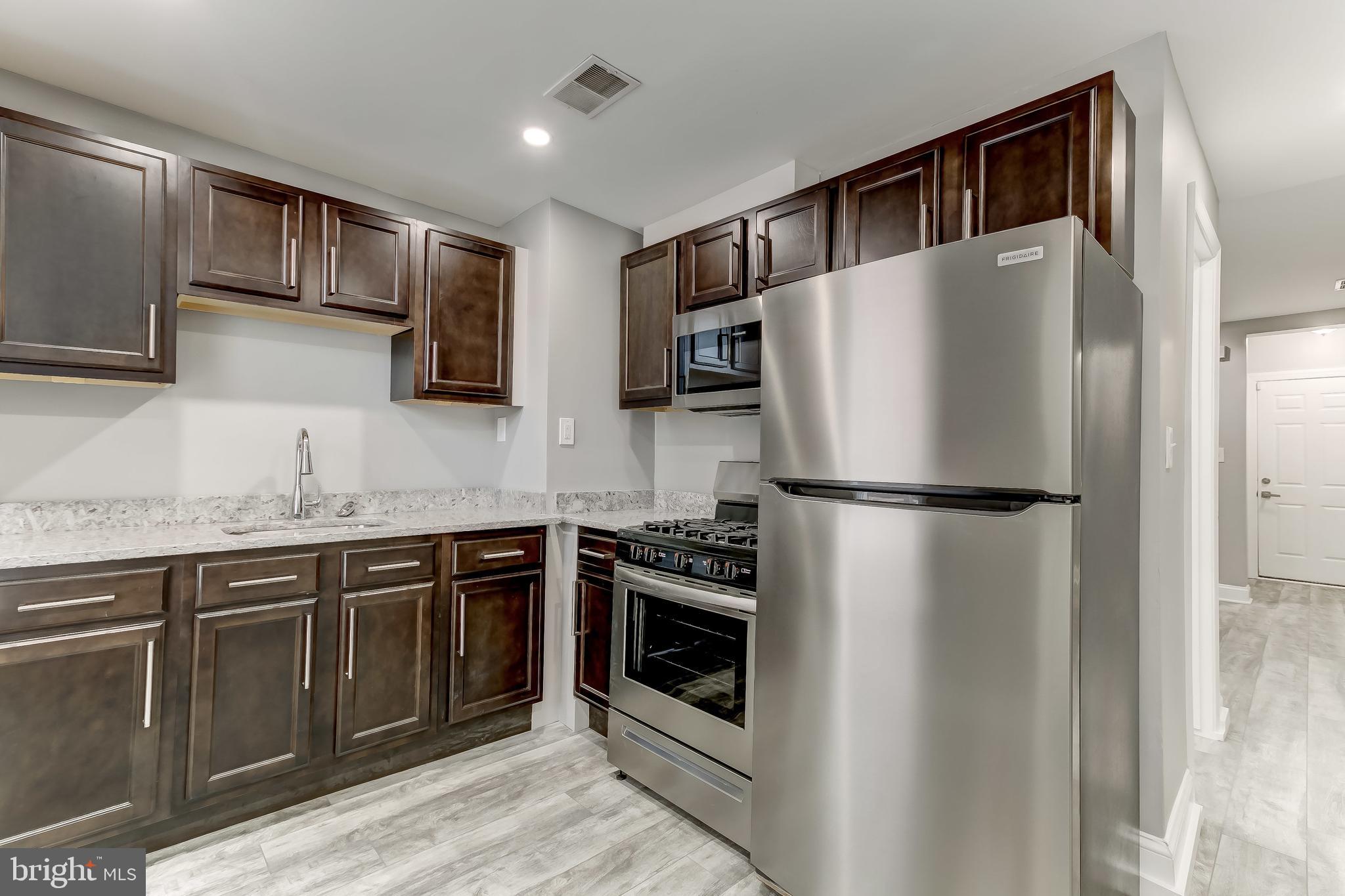 3600 Keswick Road, Unit A Baltimore, MD 21211 - Photo 32 of 43 a kitchen with stainless steel appliances granite countertop a refrigerator and a sink
