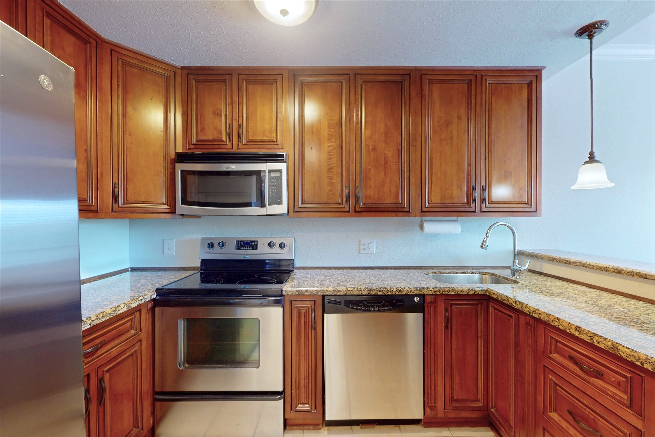 793 Davis Road, Unit 111 League City, TX 77573 - Photo 6 of 37 All the kitchen conveniences - stainless steel stove, micrwave, dishwasher, granite counters, pendant lighting over breakfast bar.