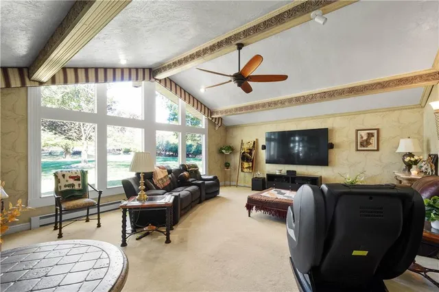 a living room with furniture fireplace and a large window