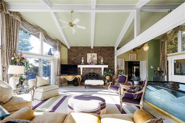 a living room with furniture a flat screen tv and a large window