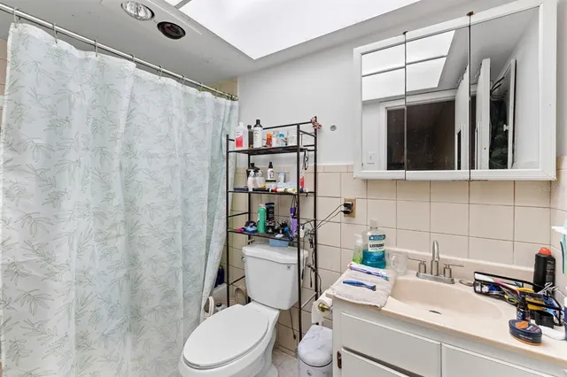 a bathroom with a sink a toilet and shower curtain