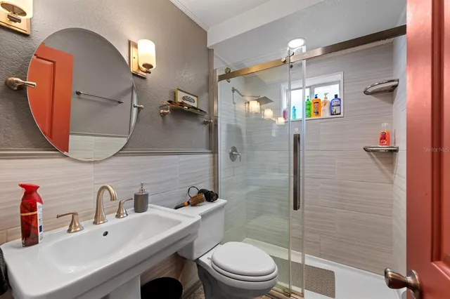 a bathroom with a sink a toilet and shower