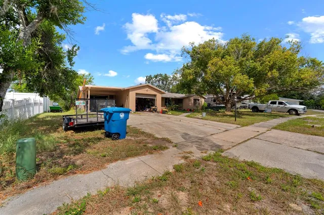 a view of a house with backyard and sitting area