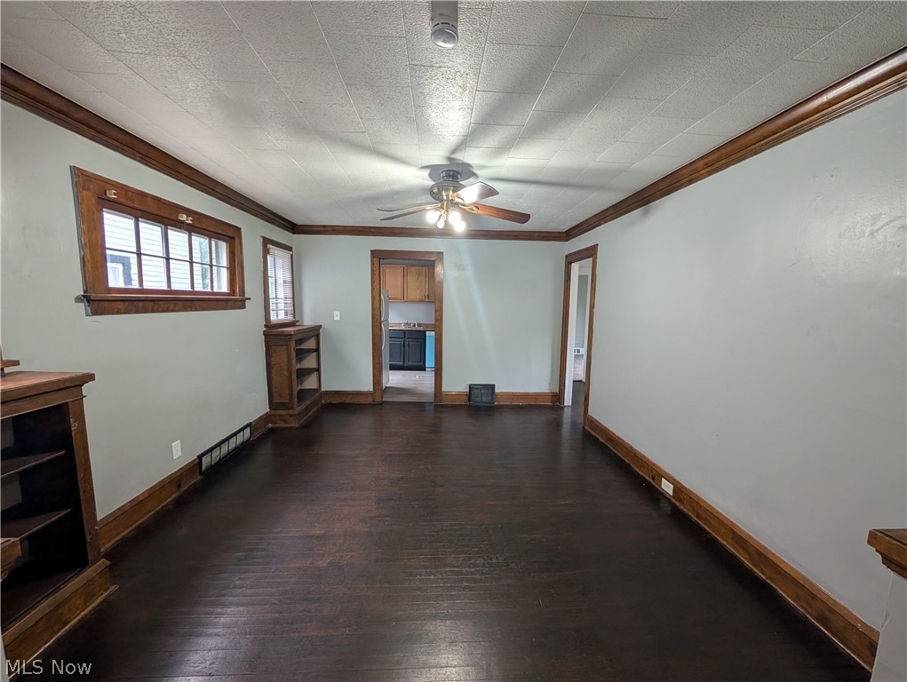 475 East 146th Street Cleveland, OH 44110 - Photo 8 of 28 Spacious room featuring dark wood-finish flooring, light-toned walls, and wood trim molding