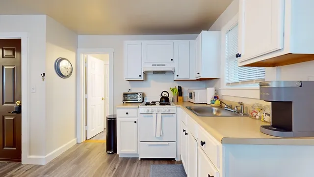 a kitchen with white cabinets and white appliances