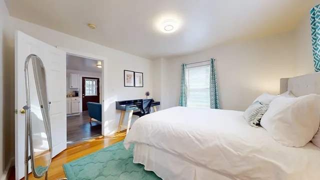 a bedroom with a bed and a dresser with mirror