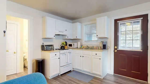 a kitchen with white cabinets and sink