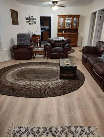 a living room with furniture a ceiling fan and a rug