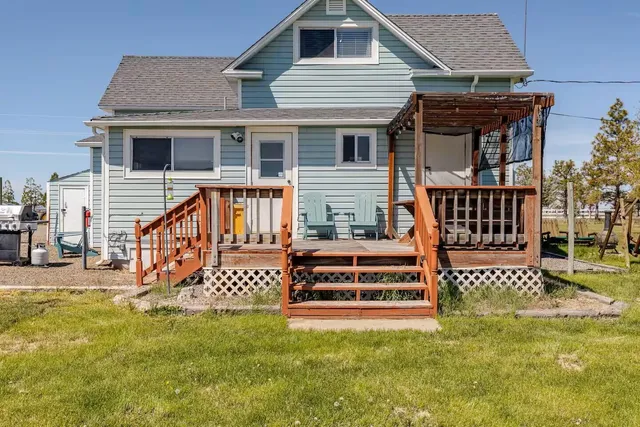 a backyard of a house with barbeque oven table and chairs