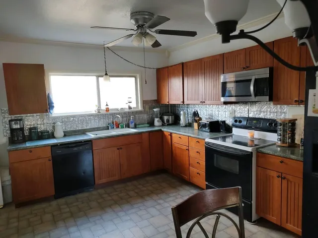 a bed sitting in a bedroom and chair next to a window
