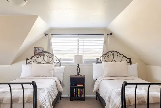 a bedroom with two beds and a window