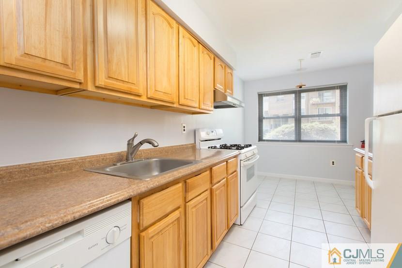 1504 Raspberry Court, Unit 1504 Edison, NJ 08817 - Photo 8 of 17 a kitchen with granite countertop a sink stainless steel appliances white cabinets and a window