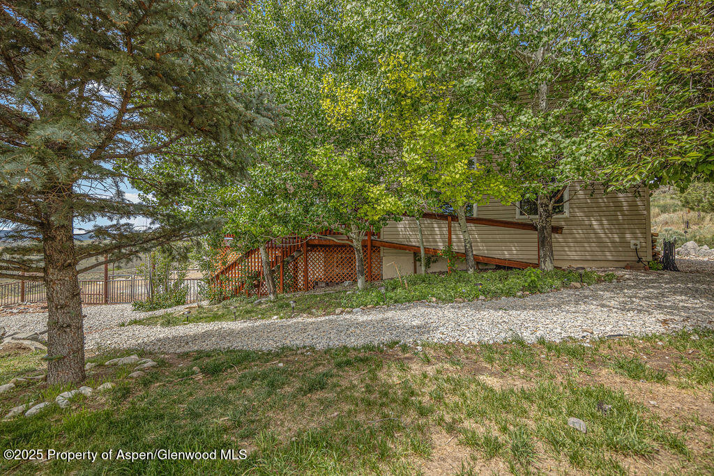 289 Lewis Lane Craig, CO 81625 - Photo 25 of 104 a backyard of a house with large trees and a wooden fence