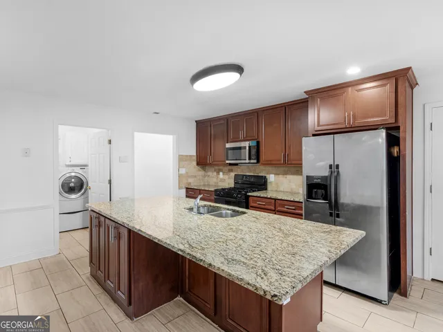a kitchen with granite countertop wooden cabinets and stainless steel appliances