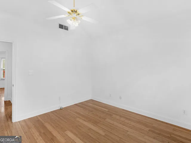 an empty room with a window and a fan