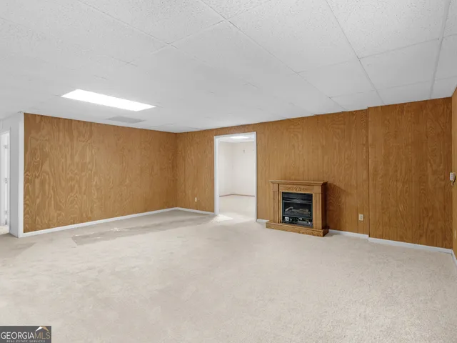 an empty room with a chandelier fan and windows