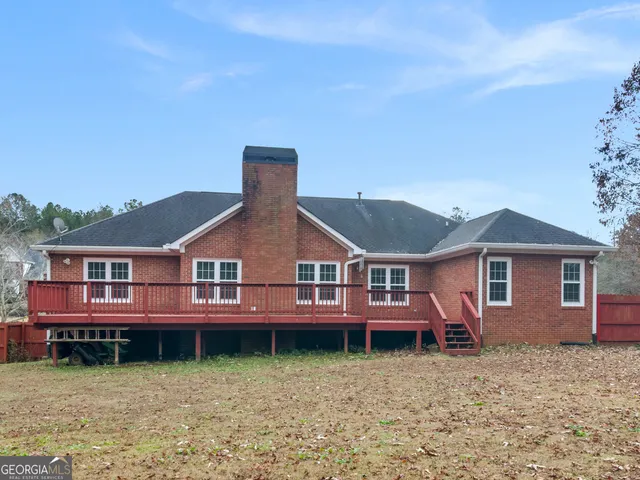 an empty room with wooden floor fireplace and windows